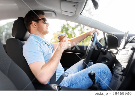 man or driver with takeaway coffee cup driving car 59469930