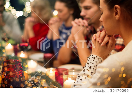 close up of friends praying at christmas dinner close up of friends praying at christmas dinner 59470096