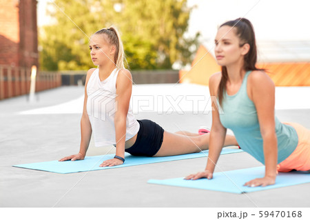 women doing sports on exercise mats outdoors 59470168