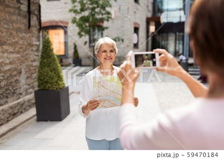 senior women with city map on street in tallinn 59470184