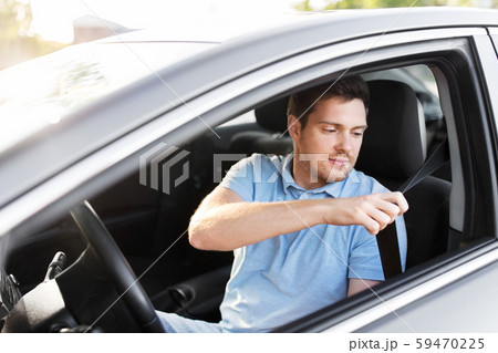 man or car driver fastening seat belt 59470225