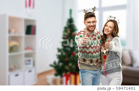 couple in christmas ugly sweaters shows thumbs up couple in christmas ugly sweaters shows thumbs up 59471401
