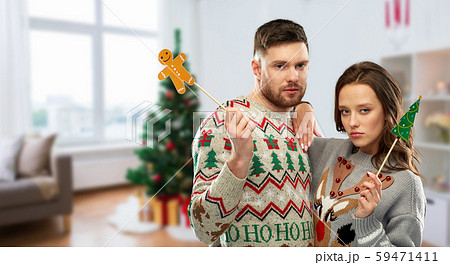 couple with christmas party props in ugly sweaters 59471411