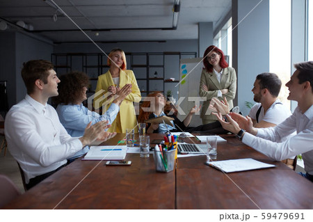Happy business people gathered around table in office 59479691