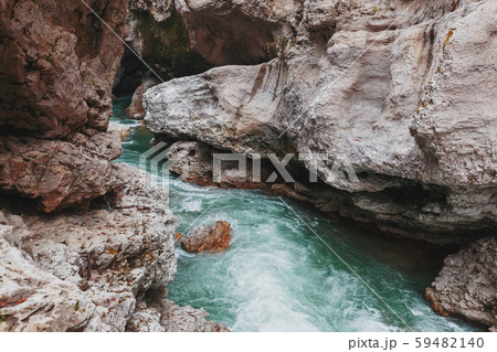 Gorge with a mountain river with a vibrant turquoise water between the rocks. 59482140