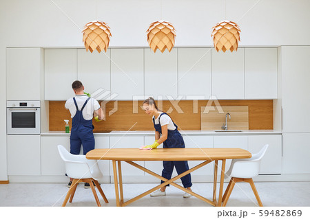 Two young janitors in blue uniform cleaning kitchen 59482869