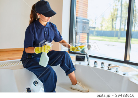 Woman with rubber yellow glove with rag washing and polishing bath Woman with rubber yellow glove with rag washing and polishing bath 59483616