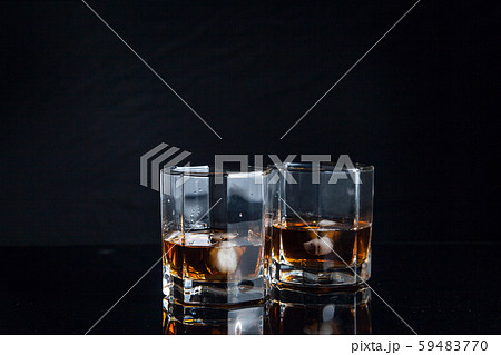 Two glasses of whiskey with ice isolated on black 59483770