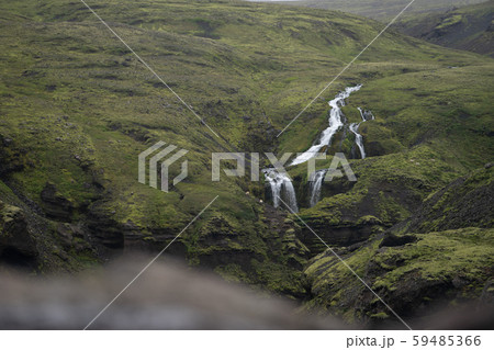 Beautiful river with tiny waterfall in Iceland surrounded by green hills Beautiful river with tiny waterfall in Iceland surrounded by green hills 59485366