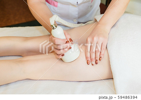 Body massage with cavitation. Young girl on massage table anti cellulite massage 59486394