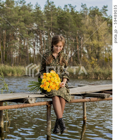 Beautiful girl with a bouquet of yellow roses. Effective woman near the river. Pretty Woman. Teen girl with yellow roses. Girl on the old bridge. Beautiful girl with a bouquet of yellow roses. Effective woman near the river. Pretty Woman. Teen girl with yellow roses. Girl on the old bridge. 59489035