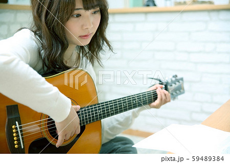 アコースティックギターを弾く女性イメージ 59489384
