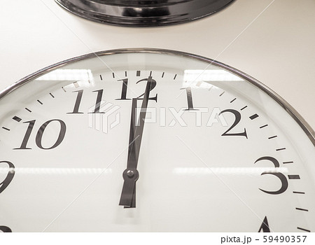 12 o'clock retro clock on white wall. The hands point to 12 o'clock, 59490357