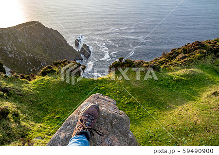 Feet trekking boots on rocky cliff edge 59490900