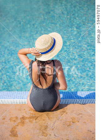 Beautiful girl in a black swimsuit near a blue 59497078