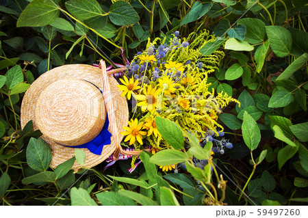 straw hat and basket with flowers stand on the straw hat and basket with flowers stand on the 59497260