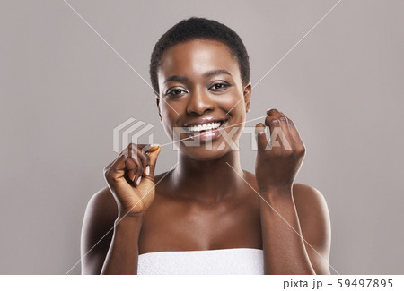 Smiling African American Woman Using Dental Floss 59497895