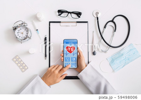 Male doctor using smartphone app to check health data Male doctor using smartphone app to check health data 59498006