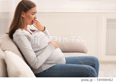 Pregnant Woman Touching Mouth Feeling Sick Sitting On Couch Indoor Pregnant Woman Touching Mouth Feeling Sick Sitting On Couch Indoor 59498462