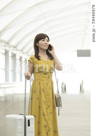 空港　動く歩道　女性　携帯電話　会話 59499976