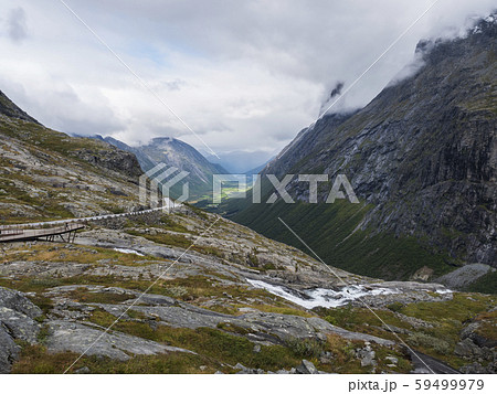 View point platform on Trollstigen or Trolls Path with green valley and waterfall at massif 59499979