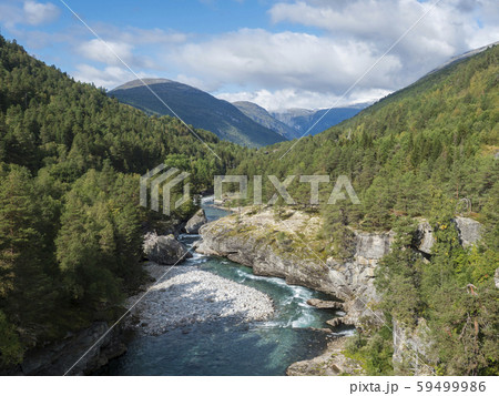 View on azure Rauma river canyon at Romsdalen valley with snow capped peaks of mountains, rocks and 59499986