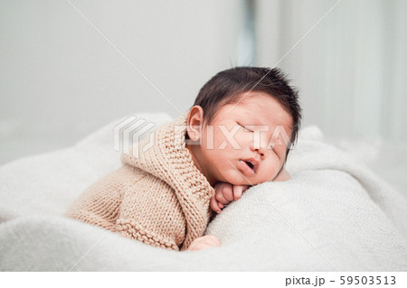 Adorable newborn baby peacefully sleeping on a white blanket. 59503513