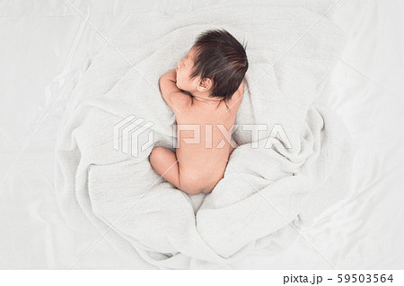 Baby sleeps on soft white blanket, Top view. 59503564