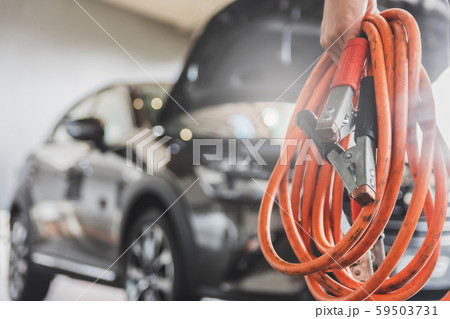 Man inspection holding jumper cables Man inspection holding jumper cables 59503731