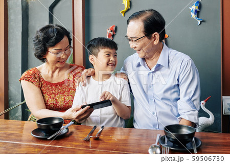 Cheerful boy at cafe with grandparents Cheerful boy at cafe with grandparents 59506730