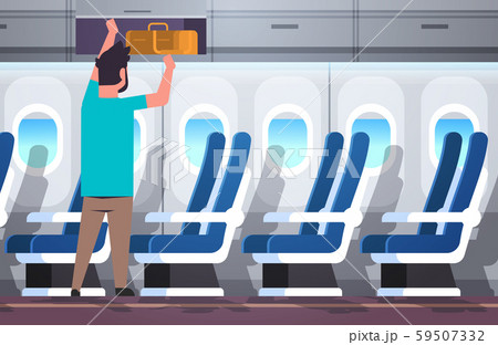 man passenger putting luggage on top shelf travel vacation concept modern airplane board interior 59507332