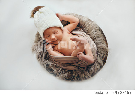 a newborn baby wrapped in a blanket with a warm hat on his head. the concept of childhood, health, IVF. a newborn baby wrapped in a blanket with a warm hat on his head. the concept of childhood, health, IVF. 59507465