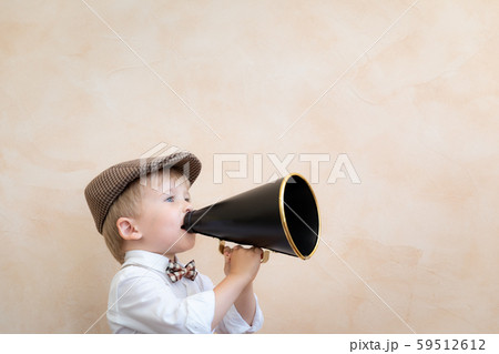 Child shouting through vintage megaphone 59512612