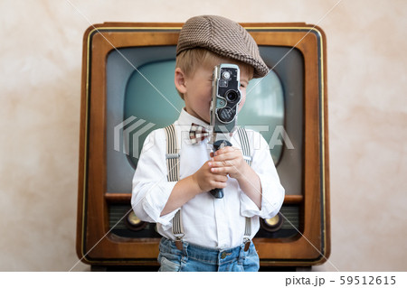 Funny kid holding vintage camera 59512615