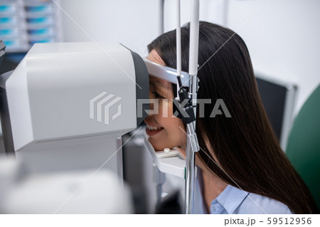 Patient smiling while visiting eye doctor and having eyesight examination 59512956