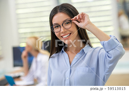 Beautiful woman smiling broadly after buying glasses at the weekend 59513015