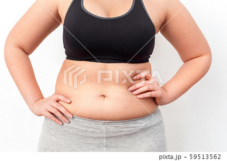 Body Care. Chubby girl with bare belly standing isolated on white hands on hips close-up 59513562