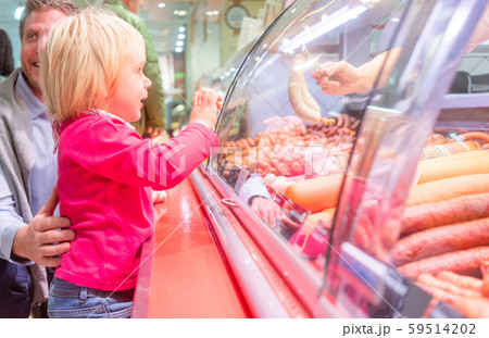 Child in front of the meat counter in a supermarket 59514202