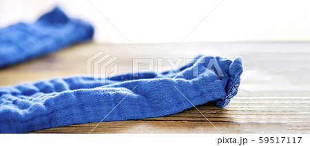 木のテーブルの上に脱ぎ捨てた青いズボンの写真素材