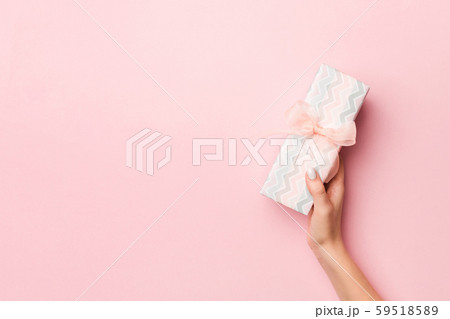 Female's hands holding striped gift box with Female's hands holding striped gift box with 59518589