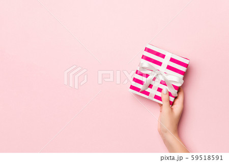 Female's hands holding striped gift box with 59518591