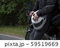 Driver riding motorcycle on an asphalt road through forest. 59519669