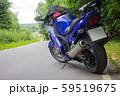 Driver riding motorcycle on an asphalt road through forest. 59519675