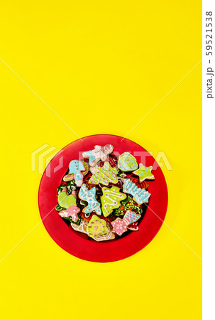 Christmas gingerbread cookies on red Xmas plate and yellow background Christmas gingerbread cookies on red Xmas plate and yellow background 59521538