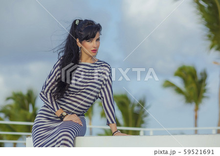 Sexy latina with long black hair at the top terrase overlooking the palm trees Sexy latina with long black hair at the top terrase overlooking the palm trees 59521691
