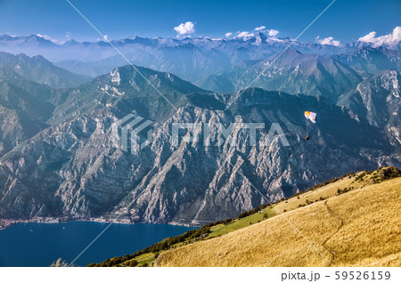 View on Alps and a paraglider over Garda lake from the mountain Monte Baldo, Lombardy, Italy. View on Alps and a paraglider over Garda lake from the mountain Monte Baldo, Lombardy, Italy. 59526159