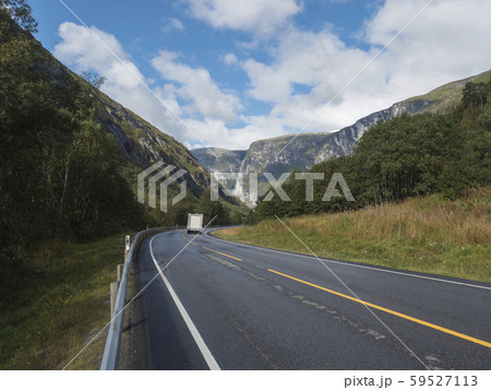 White camper van car at Winding road E136 with mountain massif Trolltindene, Troll wall Trollveggen 59527113