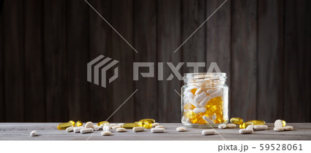 Pills in a jar on wooden background 59528061