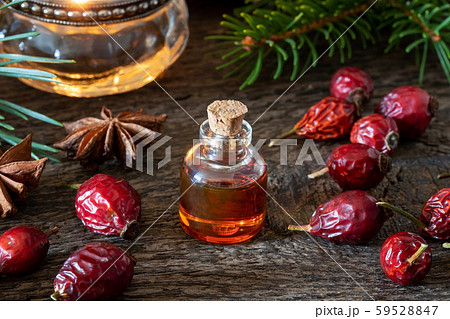 A bottle of rose hip seed oil with dried rose hips 59528847