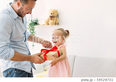 Little girl receiving present from loving dad 59529731
